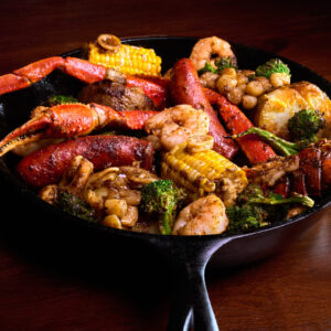 Cajun seafood boil with shrimp, crab, scallops, squid, lobster tail, sweet onion, mushrooms, broccoli, sausage, corn and potatoes
