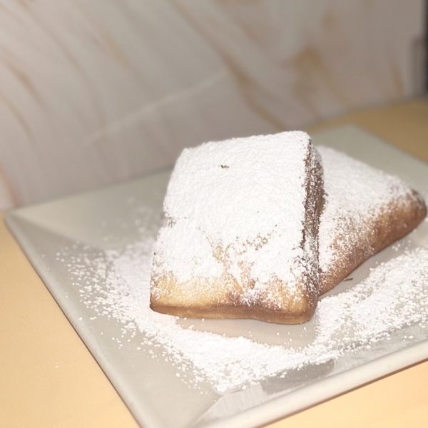 Fresh made beignet dusted with powdered sugar